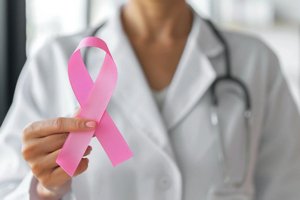 Profissional de saúde segurando fita rosa símbolo do movimento Outubro Rosa, que promove conscientização sobre o câncer de mama e a importância da prevenção.