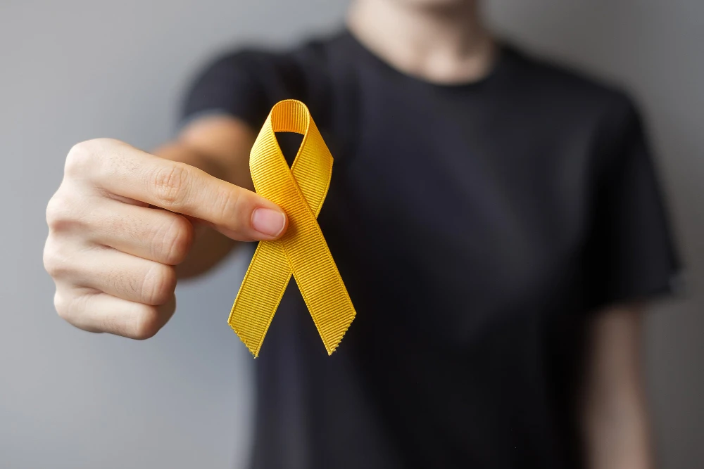 Pessoa segurando um laço amarelo, símbolo da campanha Setembro Amarelo de prevenção ao suicídio e apoio à saúde mental.