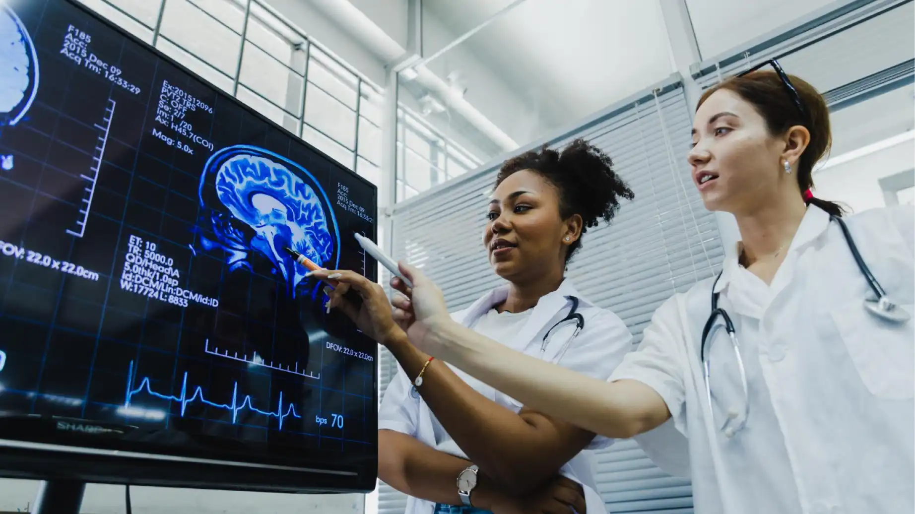 Profissionais de saúde analisando um exame de imagem de cérebro em uma tela digital, destacando o crescimento das healthtechs no Brasil, que concentra quase 65% das healthtechs latino-americanas.