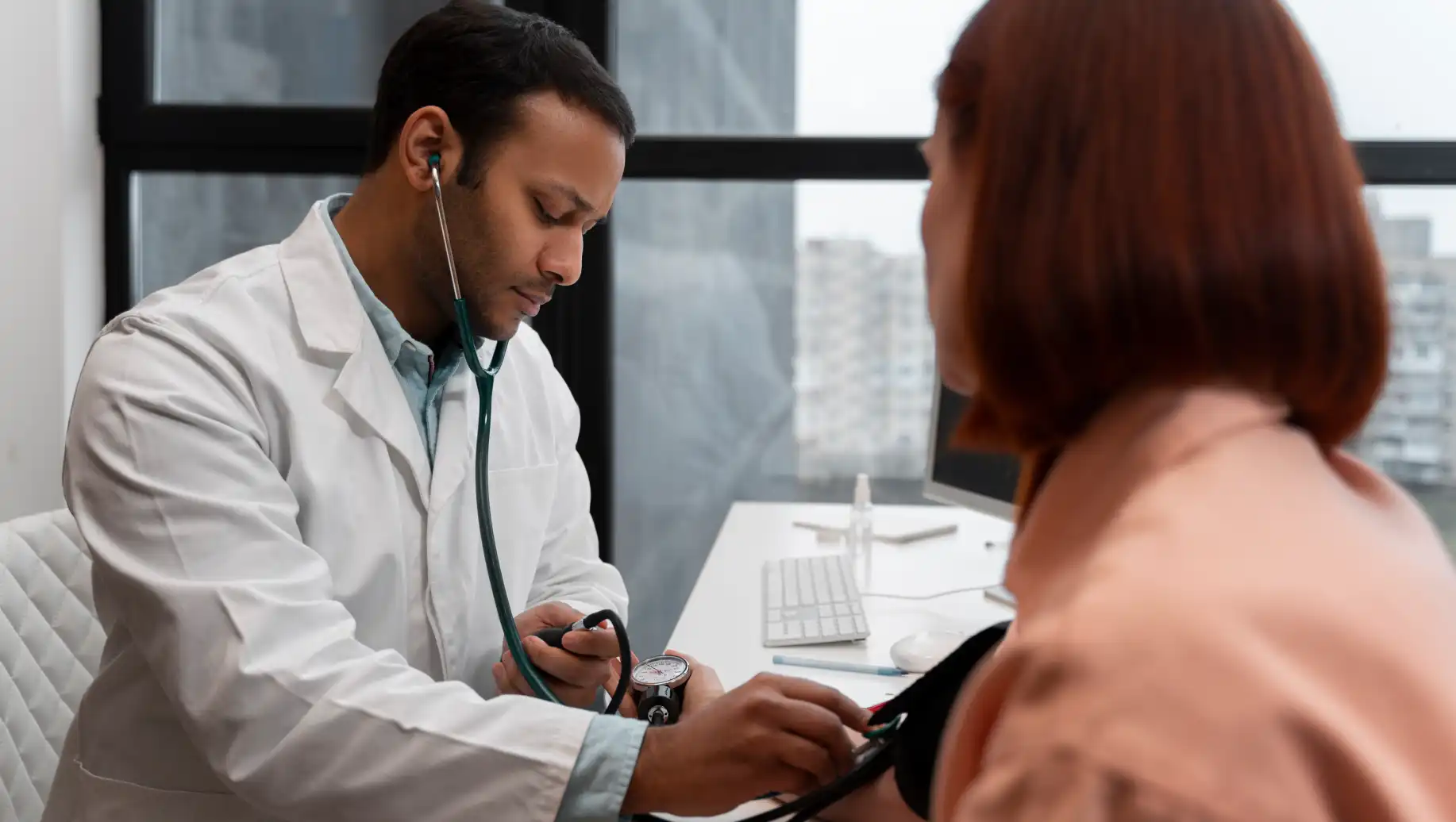 Profissional de saúde realizando aferição de pressão arterial em paciente, refletindo o aumento no número de usuários de planos de saúde em setembro.