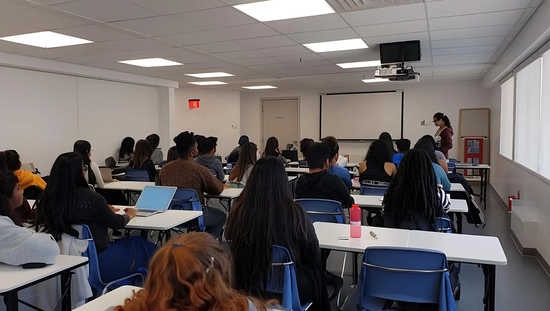 Estudantes de medicina assistem a aula em sala de aula moderna com apresentação sobre exame obrigatório para médicos recém-formados, conforme proposta do Senado.