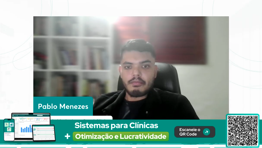Pablo Menezes, Head de Marketing da QuarkClinic, em videoconferência, sorrindo e falando para a câmera em um fundo com estante e quadro na parede.