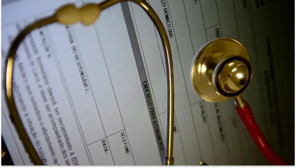 Lupa de metal dourado ampliando um formulário e uma tabela da ANS de planilha ao fundo, com anotações e campos de preenchimento visíveis, usada para análise de dados e conferência de informações.
